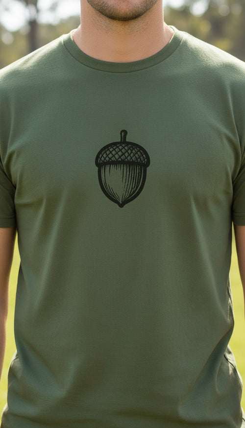 Close view of an olive green tee with a black acorn illustration. Front print.