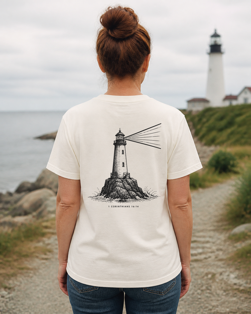 Back of a cream shirt with a lighthouse illustration and 1 Corinthians 16:14. Back print.